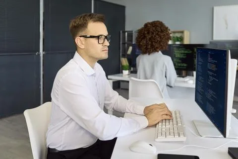Programmers working on code in tech office with computers screens and teamwork Stockfoto's