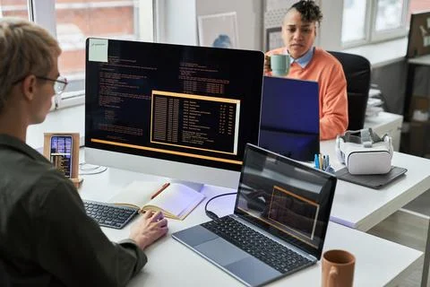 Programmers working with codes on computers in office Foto stock