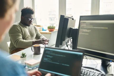 Programmers working on computers at office Stock-Fotos