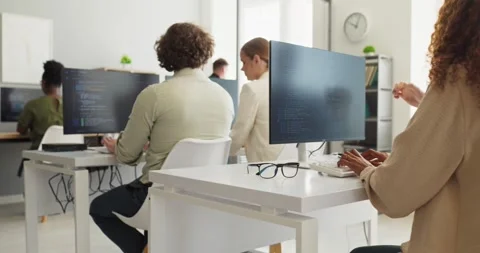 Programmers working in modern office with monitors and collaborative workflow 스톡 동영상 338172044