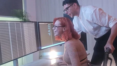 Programmers working at night analyzing code on monitors in a modern office. Video stock 333998980