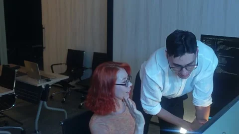 Programmers working at night analyzing code on monitors in a modern office. Stock Footage 333999025