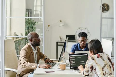 Programmers working in team on computers Fotos Stock