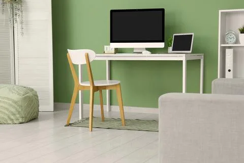 Programmer's workplace with blank laptop and computer near green wall in offi Stock-Fotos