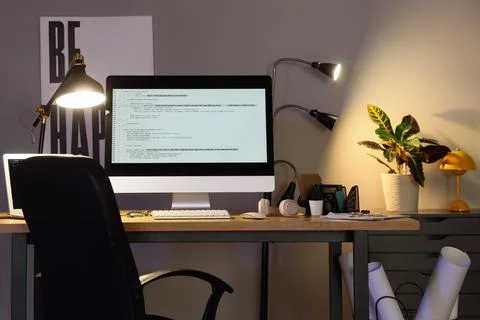 Programmers workplace with computer and glowing lamps in office 스톡 사진