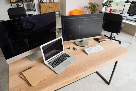 Programmers workplace with computer monitors and laptop in office 스톡 사진