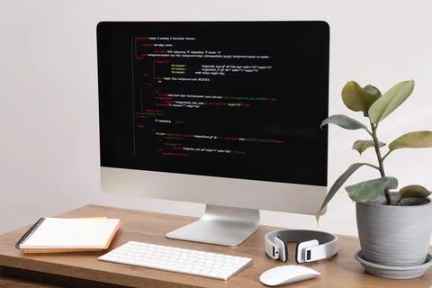 Programmer's workplace. Modern compter with unfinished code, headphones and.. 库存照片