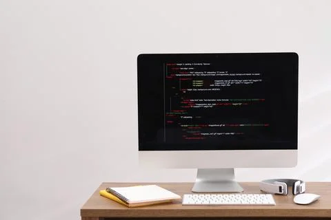 Programmer's workplace. Modern compter with unfinished code, headphones and.. 库存照片