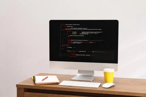 Programmer's workplace. Modern compter with unfinished code, paper cup of d.. Stock Photos