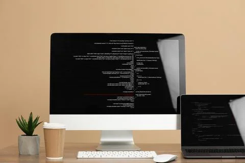 Programmer's workplace. Modern computer with unfinished code, laptop and ot.. 스톡 사진