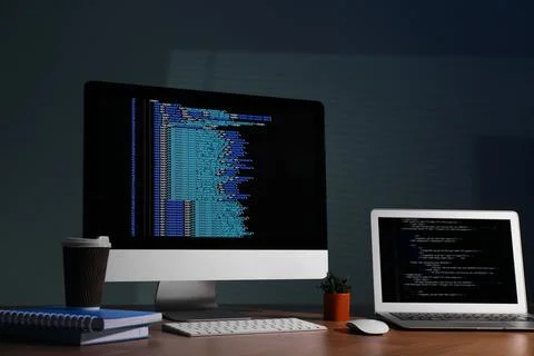 Programmer's workplace. Modern computer with unfinished code, laptop and ot.. Foto stock