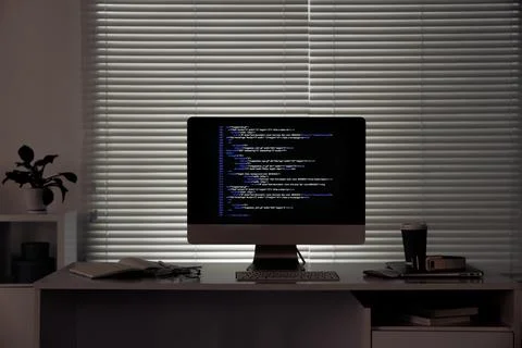 Programmer's workplace. Modern computer with unfinished code, coffee and su.. Stock-Fotos