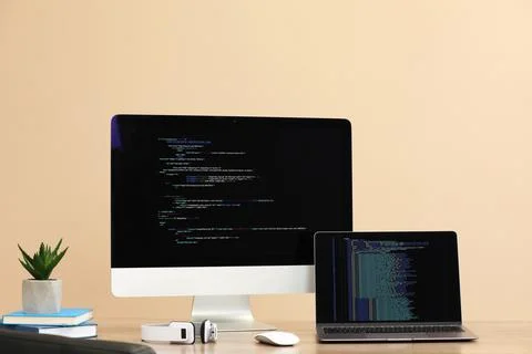Programmer's workplace. Modern computer with unfinished code, laptop and ot.. Stock Photos