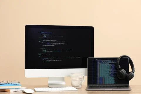 Programmer's workplace. Modern computer with unfinished code, laptop and ot.. Stock Photos