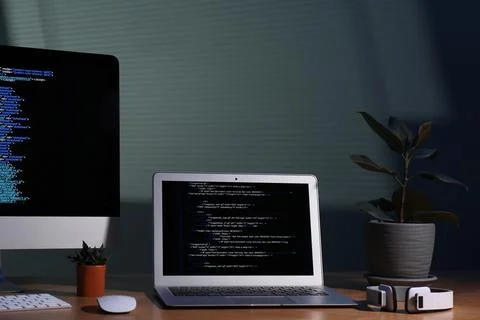 Programmer's workplace. Modern computer with unfinished code, laptop and ot.. Foto stock