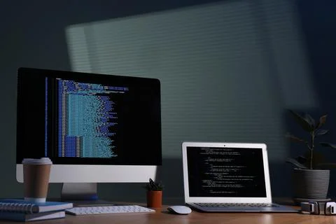 Programmer's workplace. Modern computer with unfinished code, laptop and ot.. 写真素材