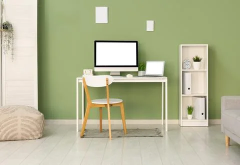 Programmer's workplace with shelf unit near green wall in office Stock-Fotos