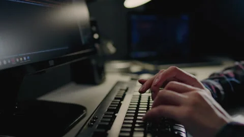 Programming and writing code, A girl is sitting at a table working on a lapt Stock Footage 247401995