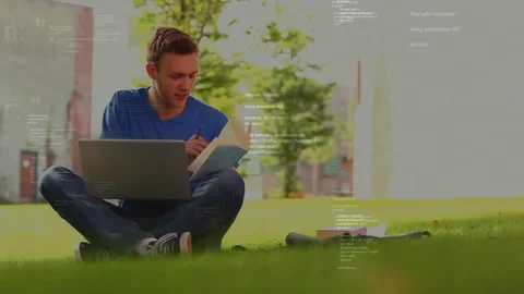 Programming code animation over young man using laptop and tablet outdoors Stock Footage 303685196