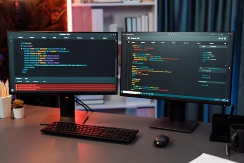 Programming code on computer two screen on desktop at neon light room. Infobahn. Foto stock