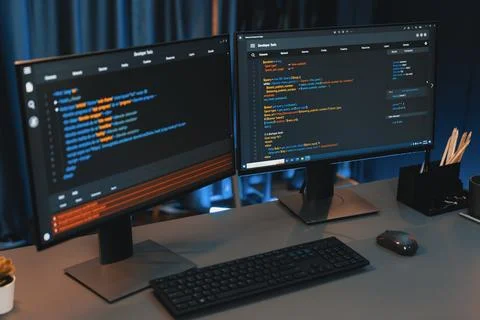 Programming code on computer two screen on desktop at neon light room. Infobahn. Foto stock