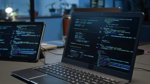 Programming Code Displayed on Laptop Connected to Digital Tablet on Grey Table Stock Footage 329609941