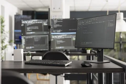 Programming code displayed on multiple computer monitors in office 스톡 사진