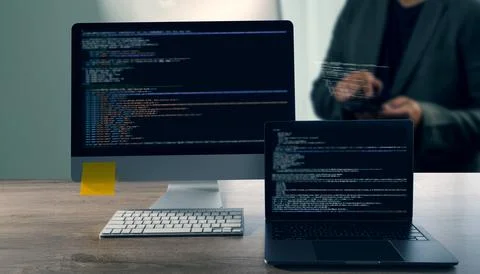 A programming code on representing close up of computer monitor and laptop di 写真素材