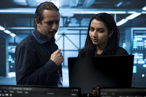 Programming, coworkers and collaboration in server room for software review Stock Photos