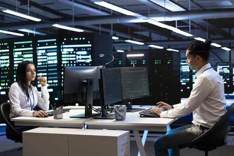 Programming, coworkers and teamwork at data center workstations Stock Photos