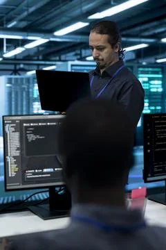 Programming, developer and laptop with coworker in data center Stock Photos