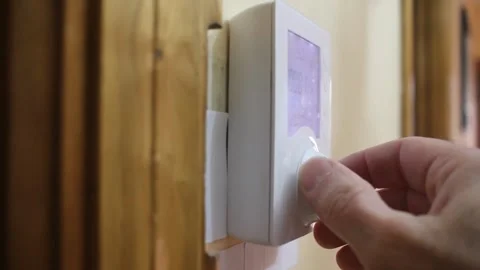 Programming a heating thermostat at home, view from the left Stock Footage 322026867