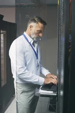 Programming, online and man with laptop in server room, review or troublesh.. Stock-Fotos