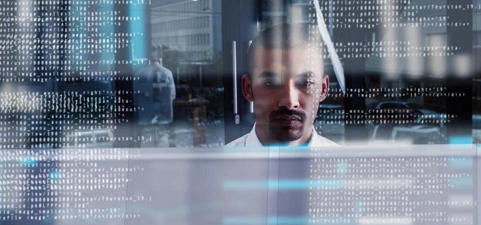 Programming like the pro that he is. a young computer programmer looking through Stock Photos