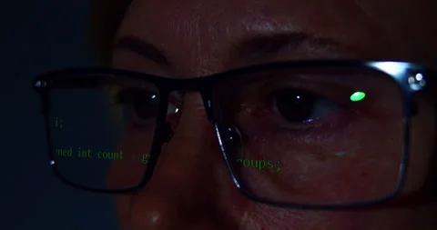 Programming script reflects on his eyeglasses as he works. Video stock 331029323