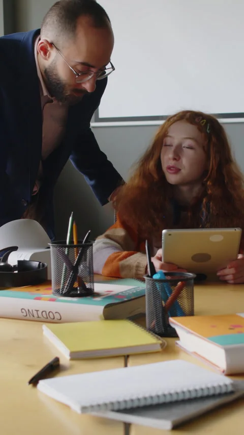 Programming Teacher Checking on Female Student Coding on Tablet in Class Stock Footage 278585492