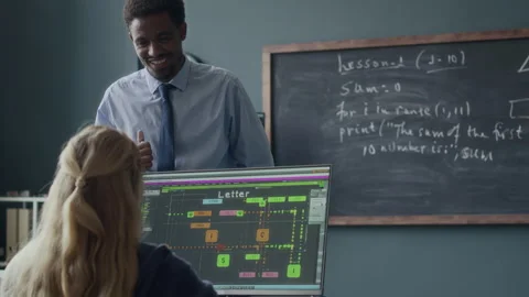 Programming Teacher Speaking to School Girl during Lesson Stock Footage 284427741