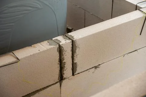 Progress of block wall construction in indoor workspace a detailed close-up.. Stockfoto's