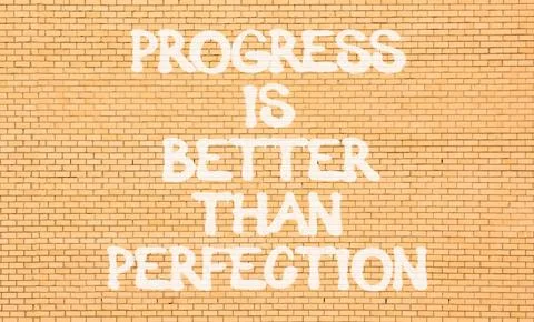 Progress or perfection words symbol. Concept words Progress is better than .. Stock Photos