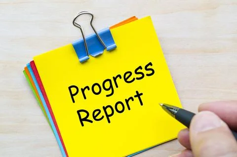 Progress report written on yellow sticky note representing project updates .. Stockfoto's