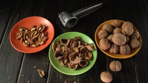 Progression of walnut preparation with cracked shells, shelled nuts, and Stock Footage 328032590