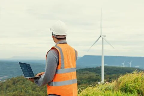 Progressive concept of engineer working in the wind farm atop of the mountain. Stock Photos