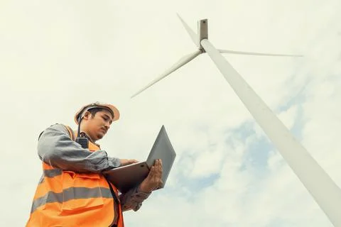 Progressive concept of engineer working in the wind farm atop of the mountain. Stock Photos