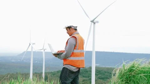 Progressive concept of engineer working in the wind farm atop of the mountain. Foto stock