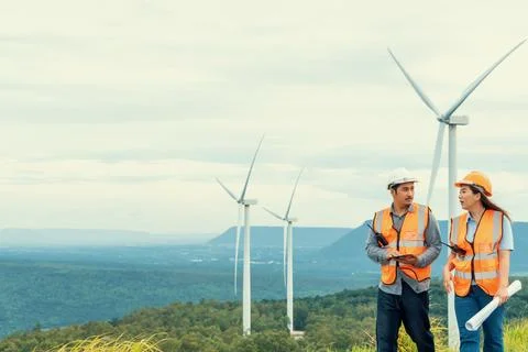 Progressive concept of engineers working in the wind farm atop of the mountain. Stock Photos
