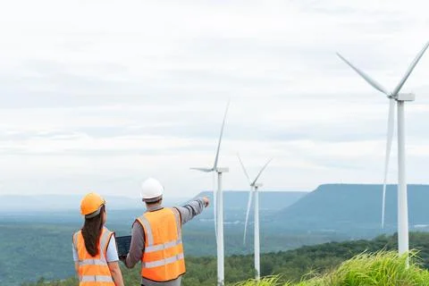 Progressive concept of engineers working in the wind farm atop of the mountain. Stock Photos