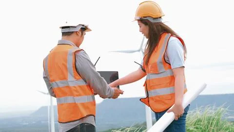 Progressive concept of engineers working in the wind farm atop of the mountain. Stock Photos