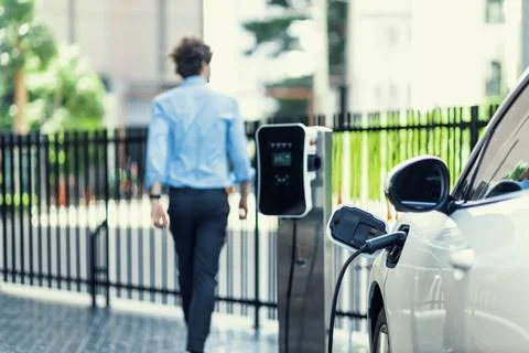 Progressive concept of focus EV car at charging station with blur man background Stock Photos