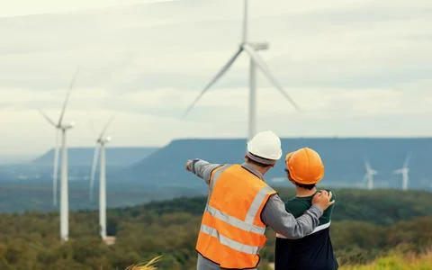 Progressive engineer with his son in the wind farm atop of the mountain. Stock Photos