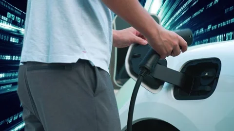 Progressive man charge electric car with technology background of binary code. Stock Footage 241007945